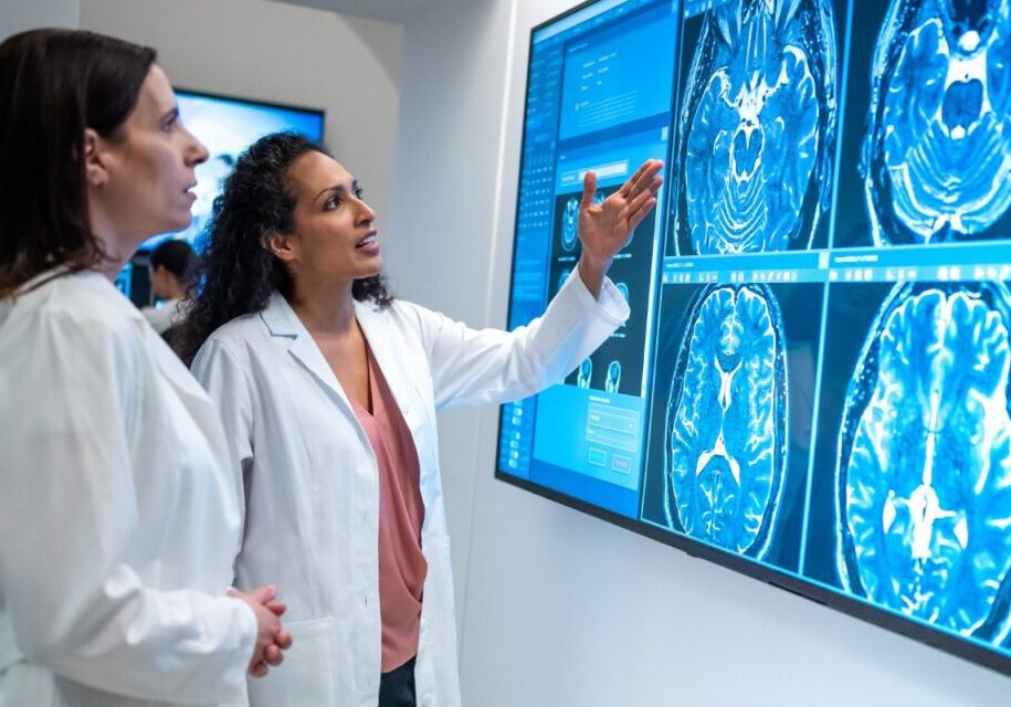 Doctors analyzing brain scans on monitor